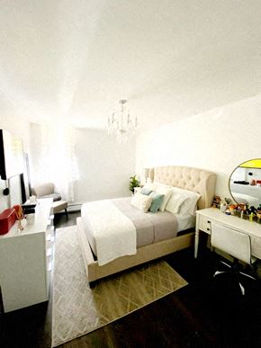 Hoboken apartment for rent - A bedroom with a large bed and a vanity table.