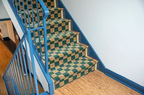 Hoboken apartment for rent - A staircase with a blue railing and green and white checkered steps.