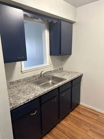 Flint apartment for rent - A kitchen with dark blue cabinets and a granite countertop.