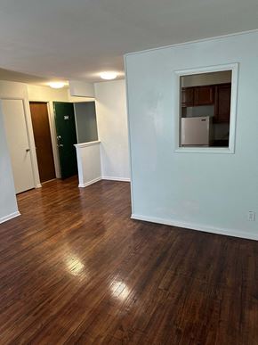 Flint apartment for rent - A room with wooden floors and a mirror on the wall.