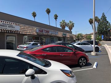 Burbank apartment for rent - a parking lot full of cars in front of a hair salon