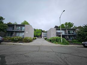 Vallejo apartment for rent - A street view of a residential area with two buildings on either side and a car parked on the right.