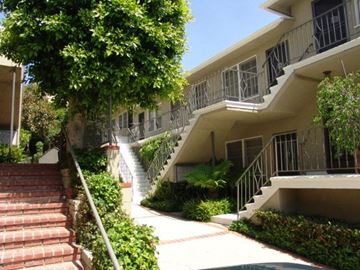 Los Angeles apartment for rent - A building with a staircase and a tree in front of it.