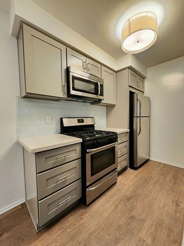 Santa Monica apartment for rent - A kitchen with a stove top oven, microwave, and refrigerator.