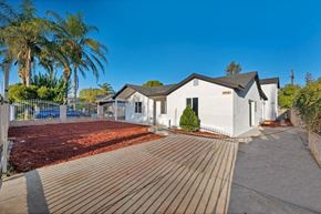 Canoga Park apartment for rent - a small white house with a yard and a deck