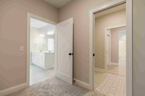 Woodbury house for rent - a bedroom with a door to a bathroom with a sink and a mirror