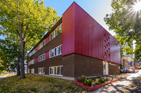 Calgary apartment for rent - A red building with a tree in front of it.
