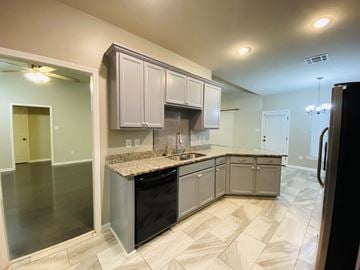 Lafayette house for rent - A kitchen with a black dishwasher and a black refrigerator.