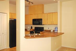 Renton apartment for rent - A kitchen with wooden cabinets and a black refrigerator.