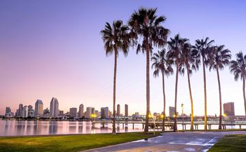 Coronado apartment for rent - a city skyline at dusk with palm trees and a pier