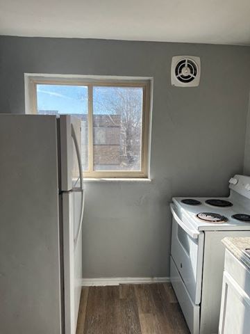 Cincinnati apartment for rent - A small kitchen with a white fridge and a white stove.