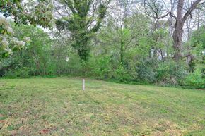 Atlanta house for rent - A grassy field with a white post in the middle and trees in the background.