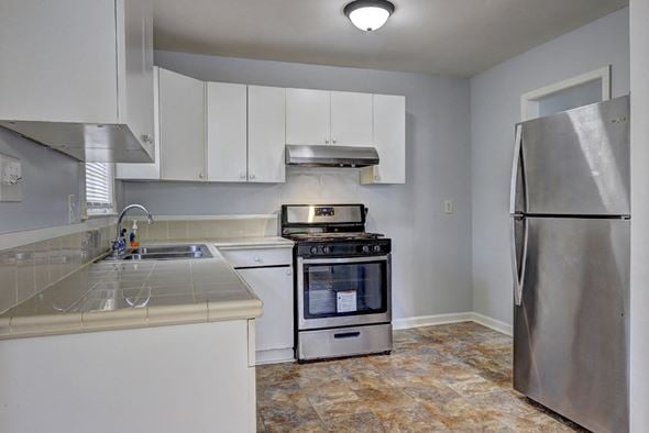 Atlanta house for rent - A kitchen with a stove top oven and a refrigerator.