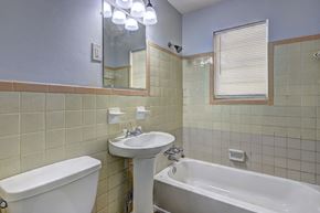 Atlanta house for rent - A white sink and bathtub in a bathroom with a mirror above it.