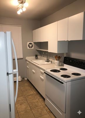 Cincinnati apartment for rent - A white kitchen with a stove, sink, and refrigerator.