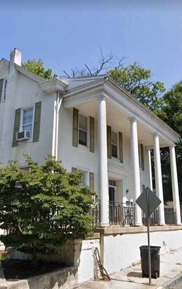 Coatesville apartment for rent - a white house with columns and a street sign in front of it
