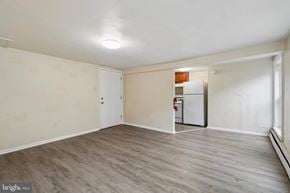 Coatesville apartment for rent - A spacious room with a white door and a white refrigerator.