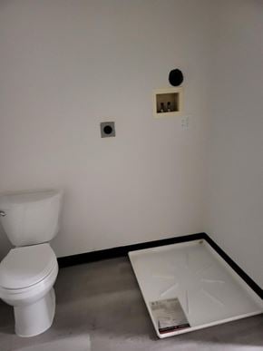 Coatesville apartment for rent - A white toilet sits next to a white tray with a black border.