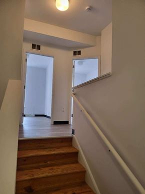 Coatesville apartment for rent - A staircase with a white wall and a door in the background.