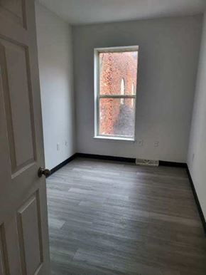 Coatesville apartment for rent - A room with a wooden floor and a window showing a brick wall outside.