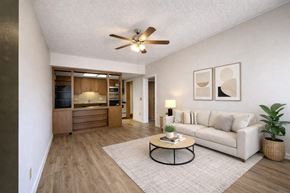 Fayetteville apartment for rent - A living room with a white couch, a coffee table, and a ceiling fan.