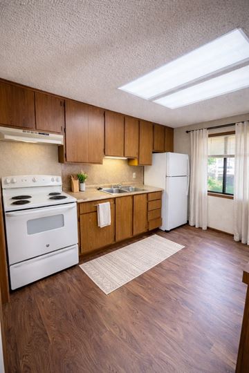 Fayetteville apartment for rent - A kitchen with wooden cabinets and a white stove top oven.