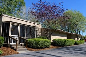 Fayetteville apartment for rent - A building with a red tree in front of it.