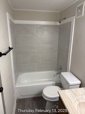 Fayetteville apartment for rent - A bathroom with a toilet, tub, and towel rack.
