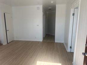 Los Angeles apartment for rent - A room with white walls and wooden flooring with a door on the left and a door on the right.