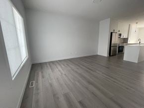 Edmonton apartment for rent - an empty living room with wood flooring and a kitchen