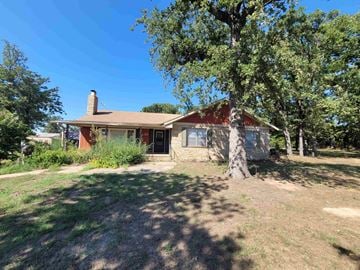 Shawnee house for rent - A house with a red roof and a tree in front of it.