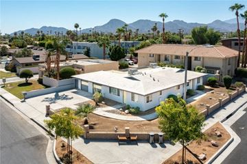 Palm Desert apartment for rent - an aerial view of a building with palm trees and a parking lot