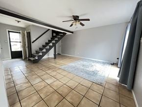 Atlanta house for rent - an empty living room with a ceiling fan and a staircase