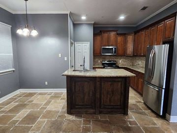 Copperas Cove house for rent - a kitchen with a center island and a stainless steel refrigerator