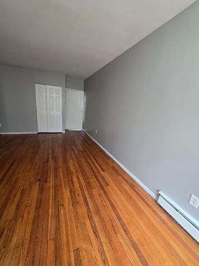 Cincinnati apartment for rent - A room with wooden floors and a white door.