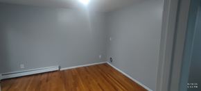 Cincinnati apartment for rent - A room with wooden floors and white walls.