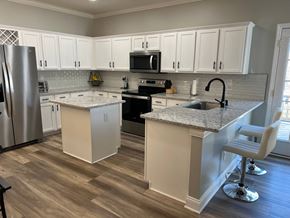 Waxhaw house for rent - a kitchen with white cabinets and a counter top