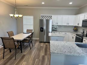 Waxhaw house for rent - a kitchen and dining area with a stainless steel refrigerator