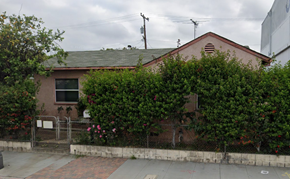 Commerce apartment for rent - A house with a grey roof and a brown wall covered in green plants.