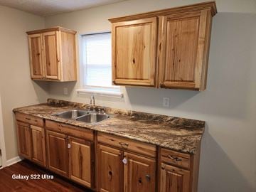 Clearfield house for rent - A kitchen with wooden cabinets and a marble countertop.