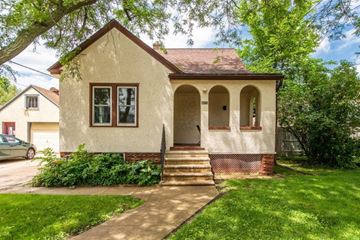 Rochester house for rent - a small tan house with stairs in front of a yard