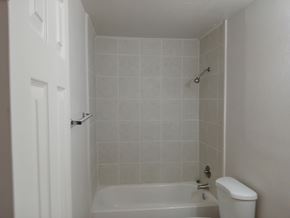 Fairfield apartment for rent - A white bathroom with a tub, toilet and shower.