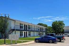 Fairfield apartment for rent - A blue car is parked in front of a white building with a sign.