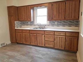 Warren house for rent - an empty kitchen with wooden cabinets and a sink
