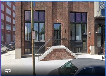 Dayton apartment for rent - A brick building with a black door and windows.