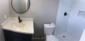 Brownsville apartment for rent - a bathroom with a toilet and a sink and a mirror