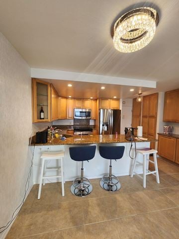 Honolulu apartment for rent - A kitchen with a bar area and a chandelier hanging from the ceiling.