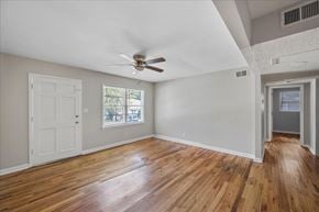 Roswell apartment for rent - A room with a ceiling fan and wooden floors.