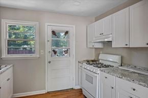 Roswell apartment for rent - A kitchen with white cabinets and a marble countertop.