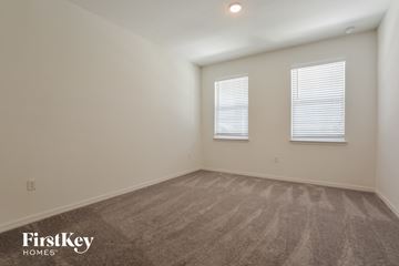 Kissimmee house for rent - the living room of an apartment with carpet and two windows